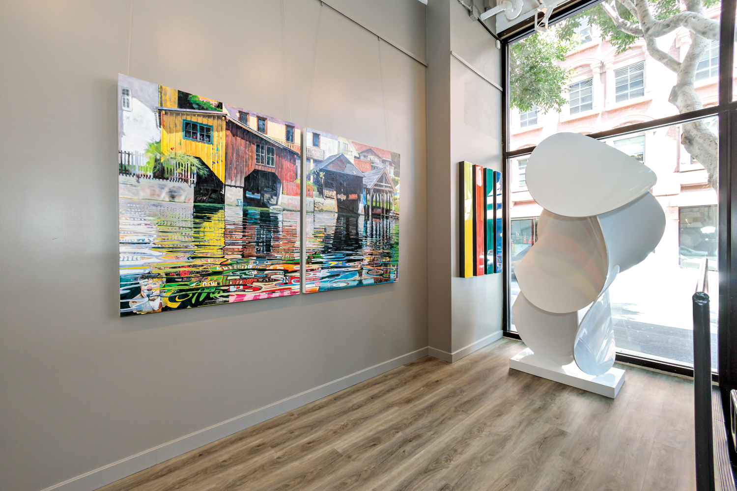 Gallery with gray walls featuring colorful artworks and a white sculpture by Stephanie Breitbard