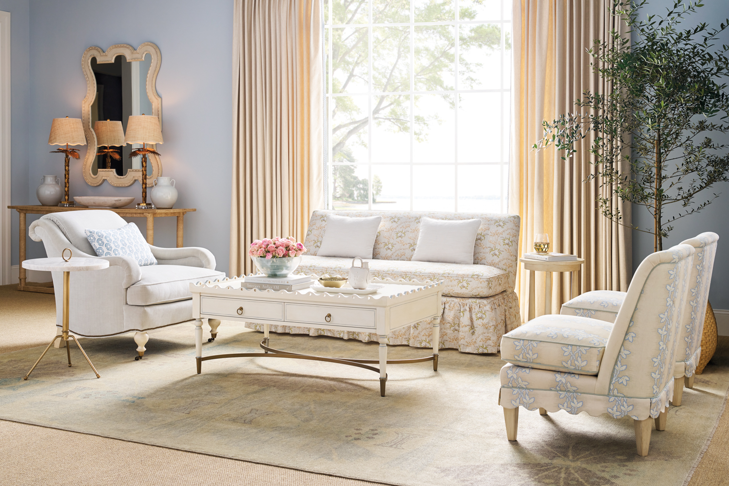 Living room seating area with a cream-patterned skirted sofa and armchairs by Nellie Howard Ossi