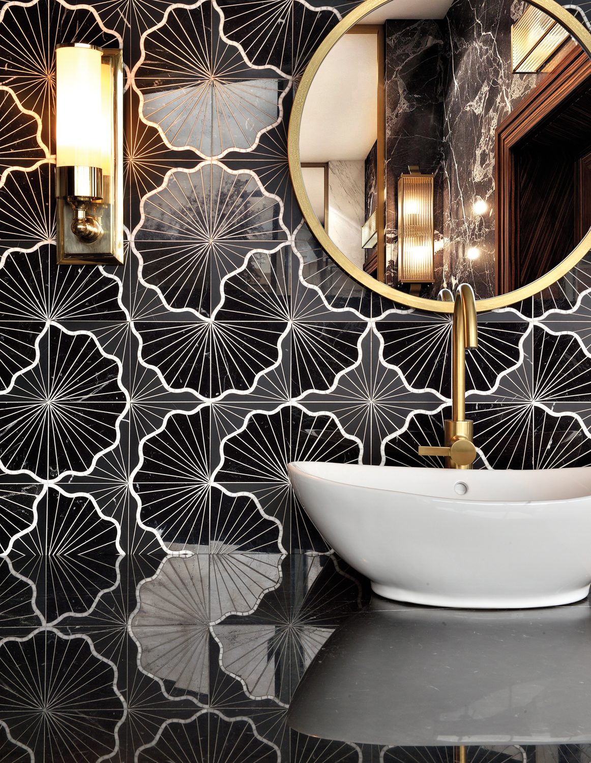 black-and-white tile by Stone Boutique in bathroom with white sink and gold-toned faucet, round mirror and sconce
