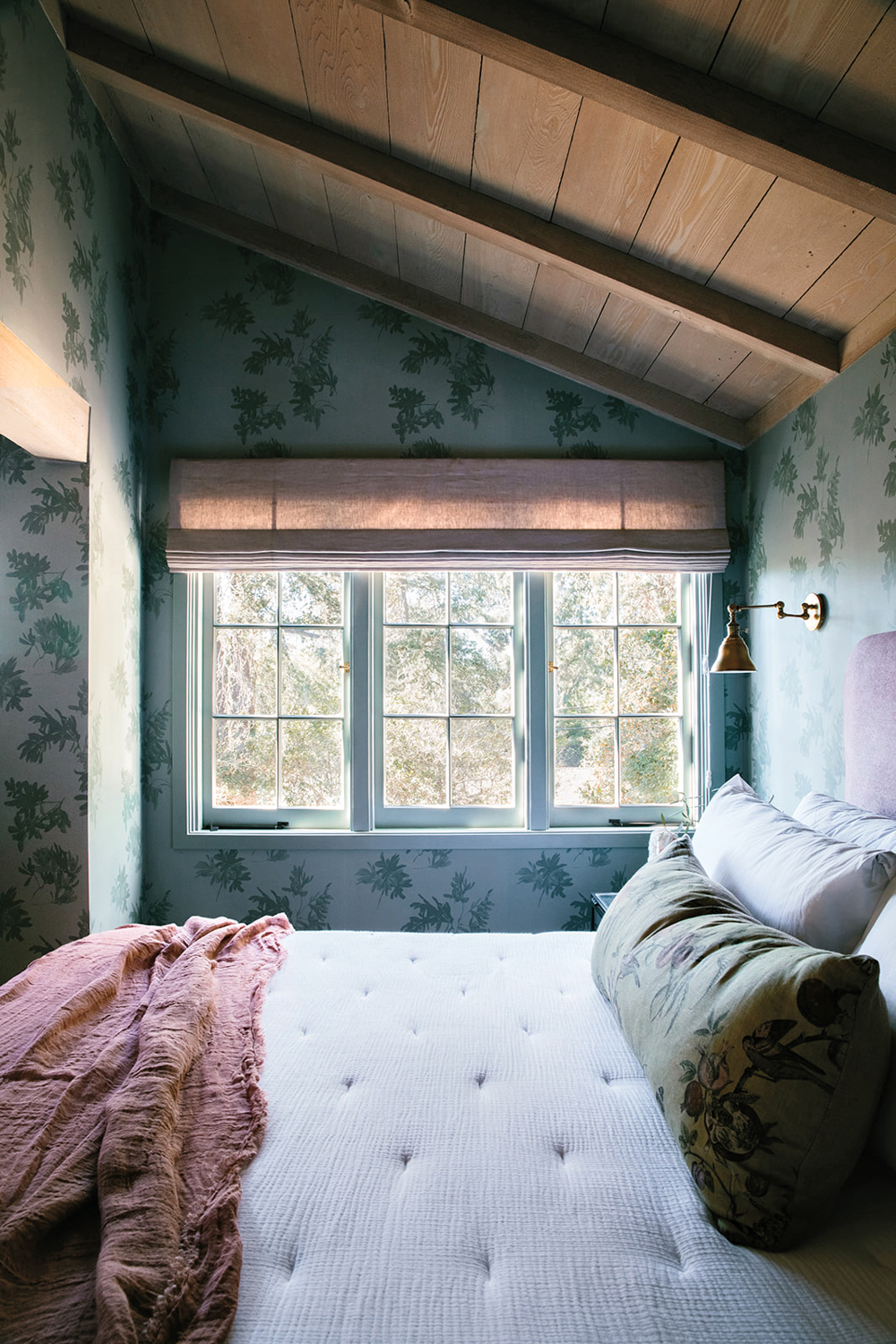An attic bedroom with a blue patterned wallpaper