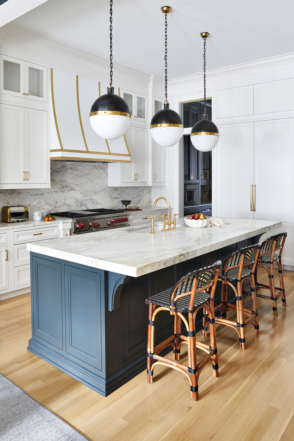 White-blue-and-brass kitchen with a quartzite-topped...