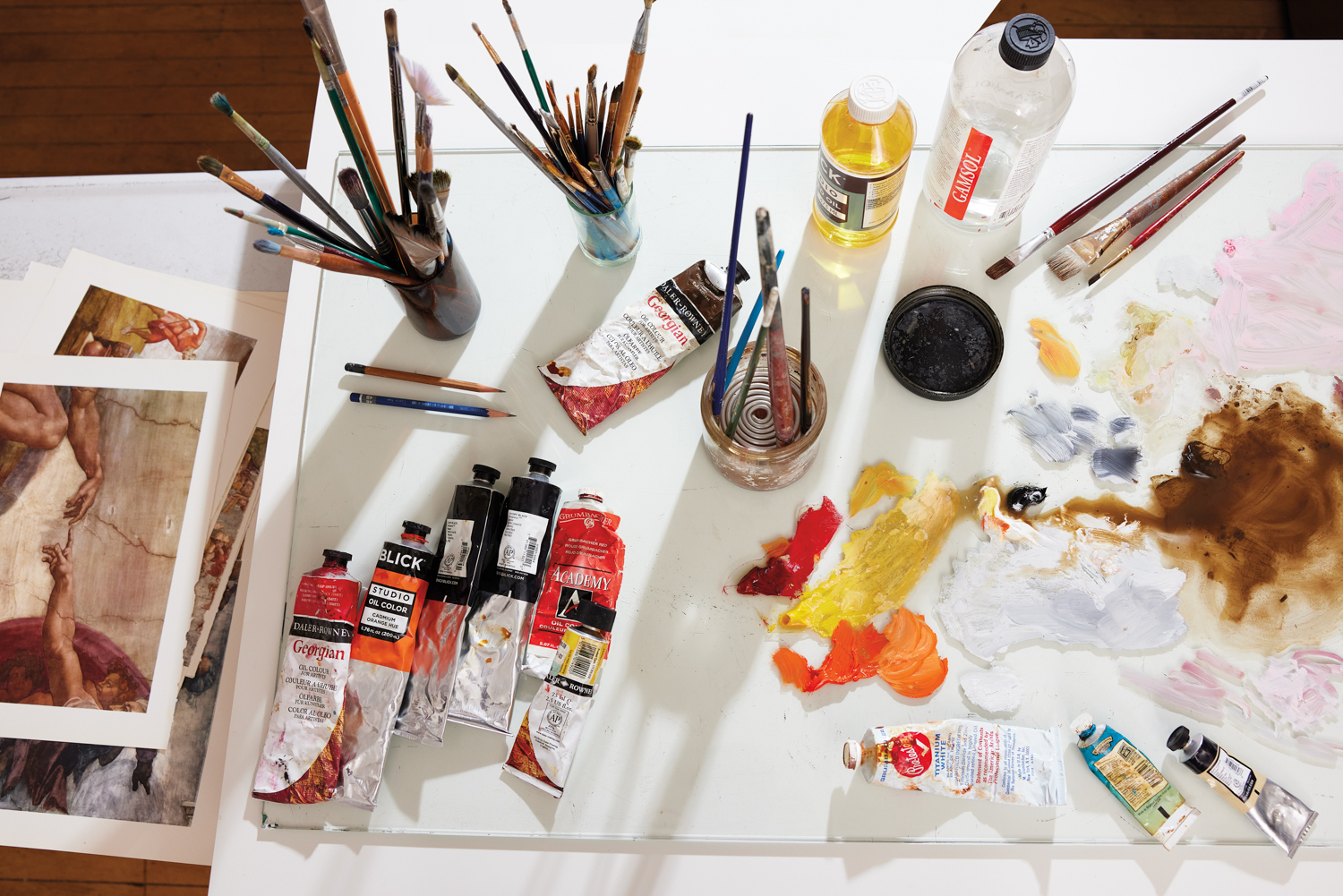 paint tubes, paint and brushes on a white table