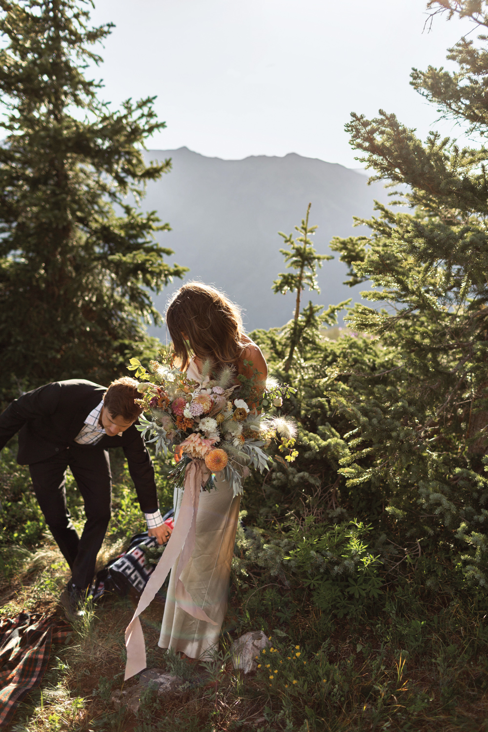 A bride holding a bouquet next to a groom in nature in feed by Little Hollow Flowers