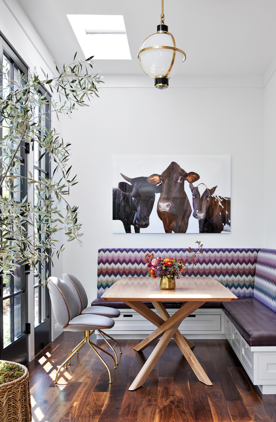 sunroom with purple banquette, table and portrait of buffalo