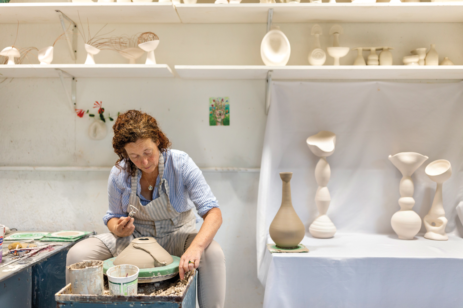 Ceramicist Anja Palombo manipulates clay on the potter’s wheel in her Sarasota studio
