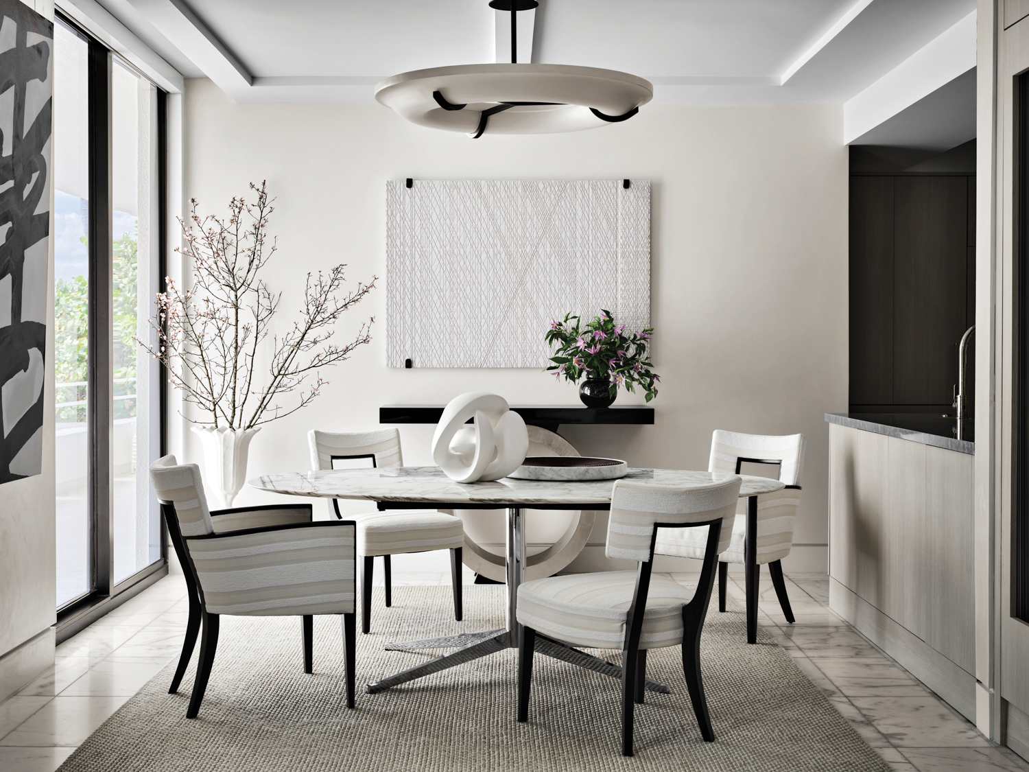 all-white dining area with round...
