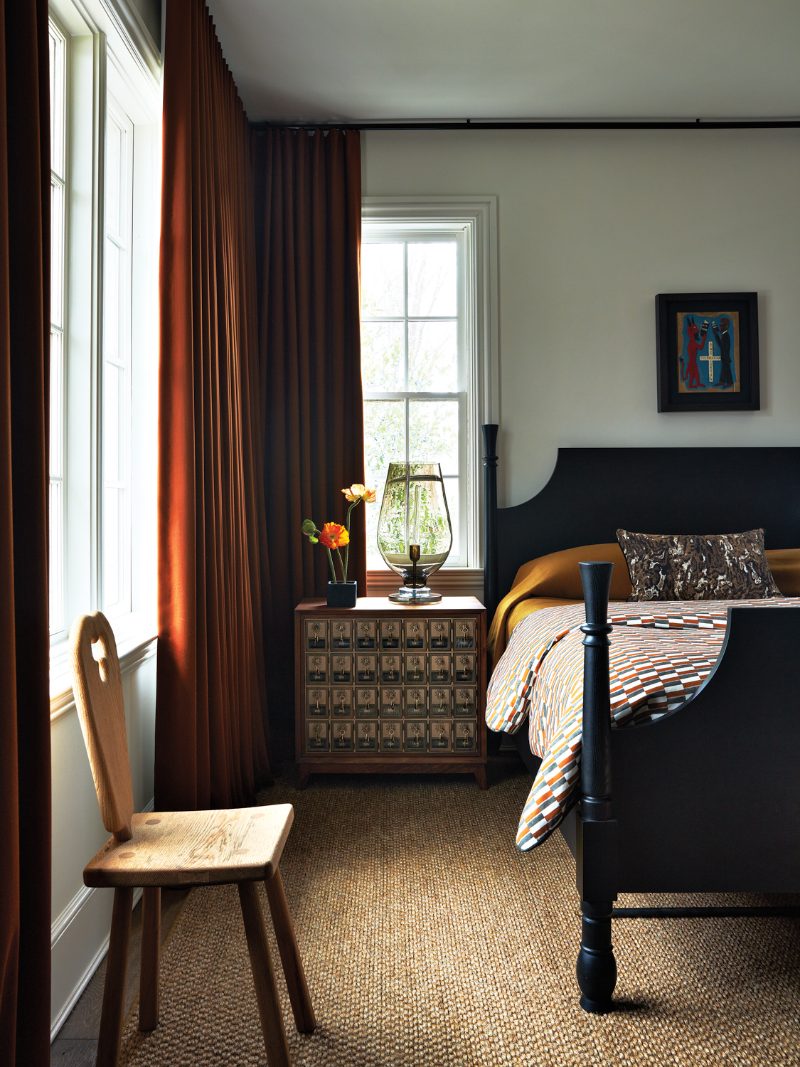 Bedroom with rust-colored draperies, a...