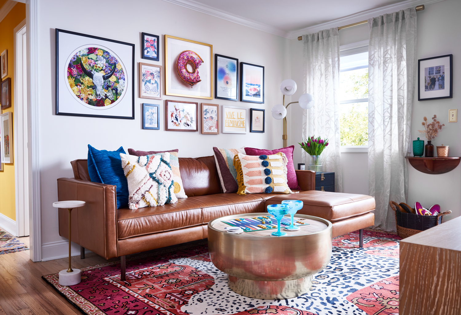 bright living room with tan couch and pink and blue accent pillows