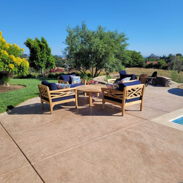 Teak outdoor furniture with deep seating on outdoor patio next to pool in California