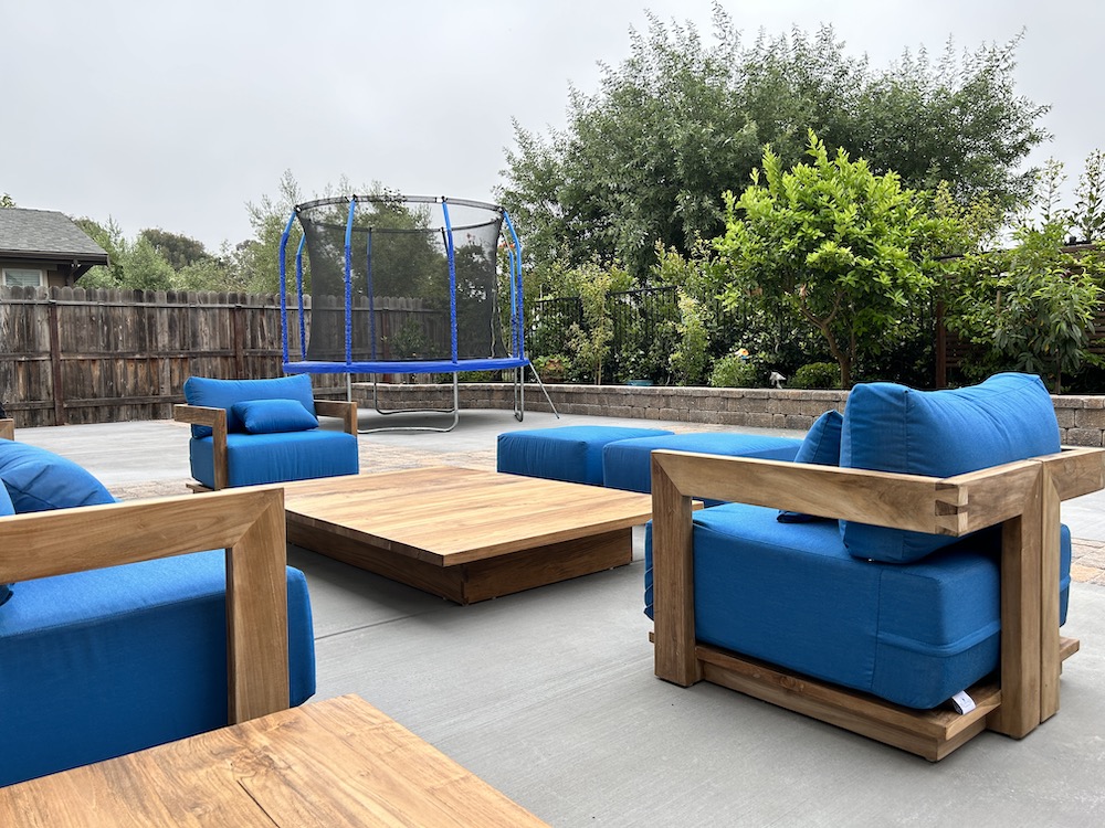 Teak outdoor deep seating sofa and table with teal cushions on outdoor patio by Willow Creek Designs in Los Angeles, California