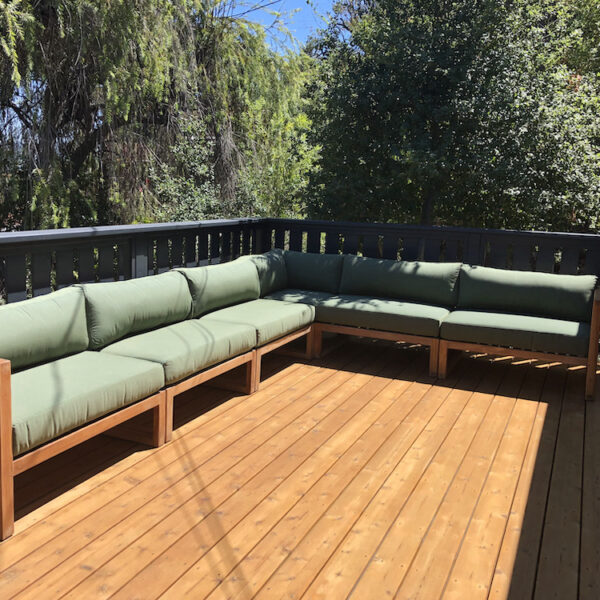 Teak outdoor sectional with green cushions on outdoor patio by Willow Creek Designs in Los Angeles, California