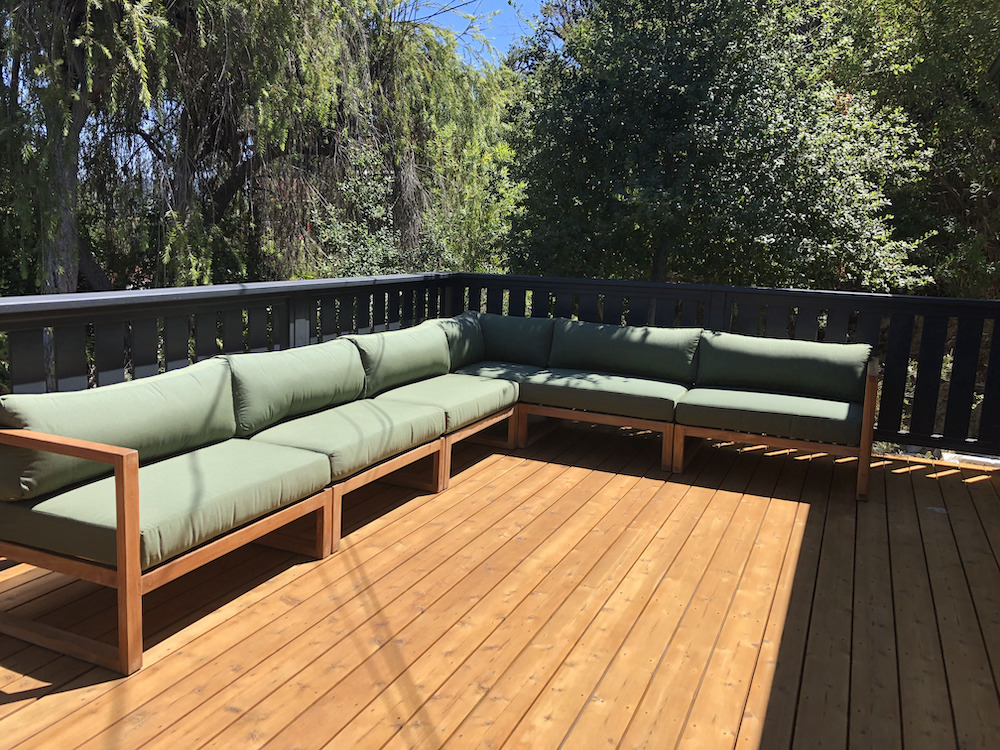 Teak outdoor sectional with green cushions on outdoor patio by Willow Creek Designs in Los Angeles, California