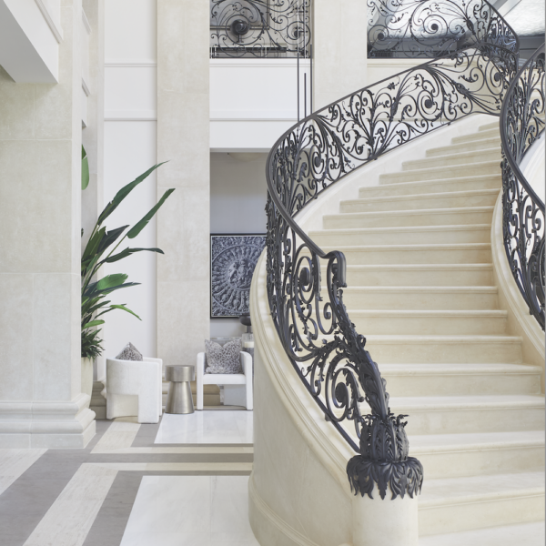François & Co. Stonework in grand foyer with circular staircase with custom metalwork