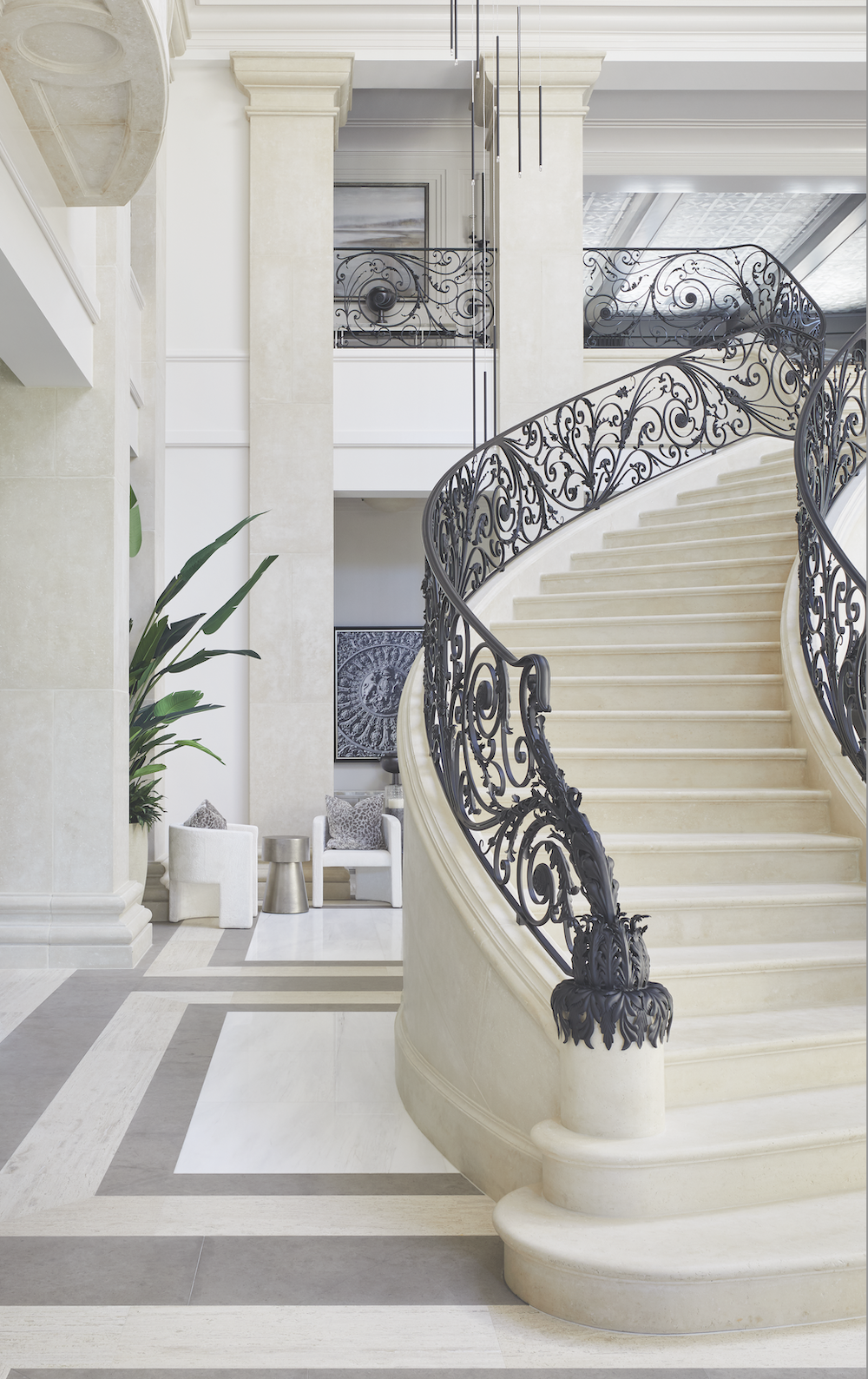 François & Co. Stonework in grand foyer with circular staircase with custom metalwork