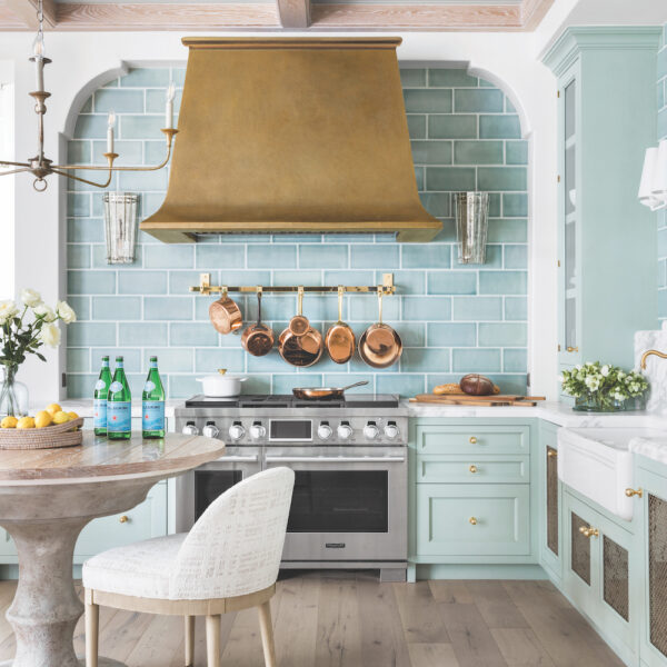 The Brassier Range Hood in open kitchen with teal blue tile backsplash and cabinets