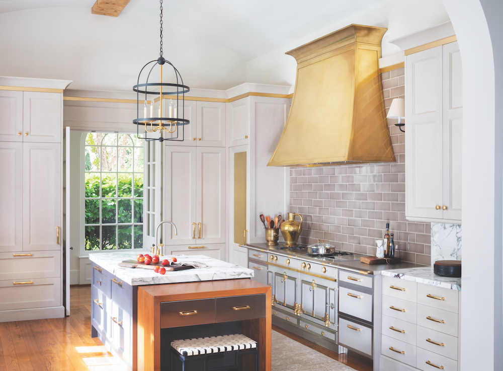The Arcadia Hood by Francois & Co in kitchen with white cabinets and gold accents
