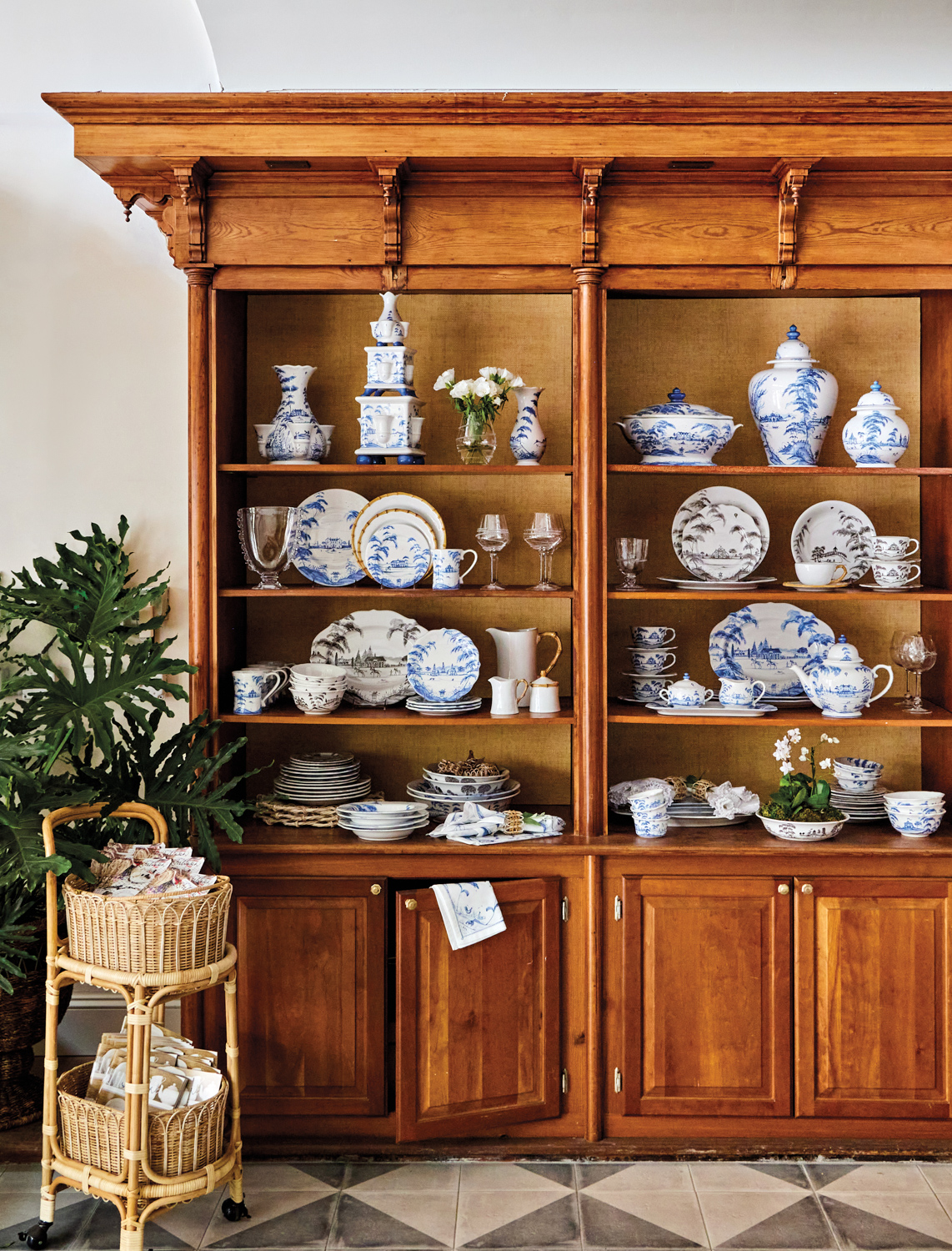 Juliska interior with large wood china cabinet filled with blue-and-white dishes, vases and cannisters