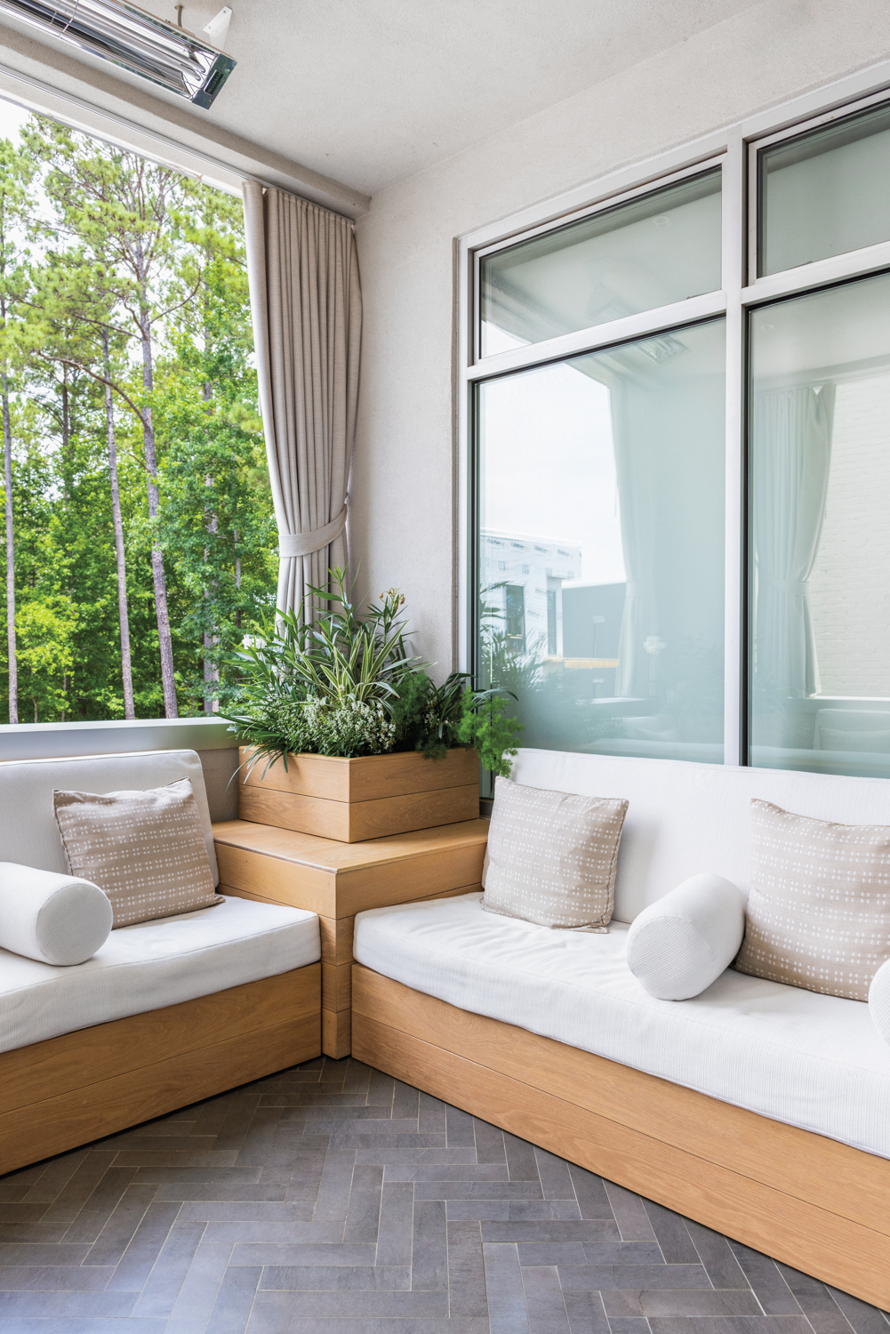 Spa at Serenbe balcony with L-shaped benches, white cushions and tan throw pillows