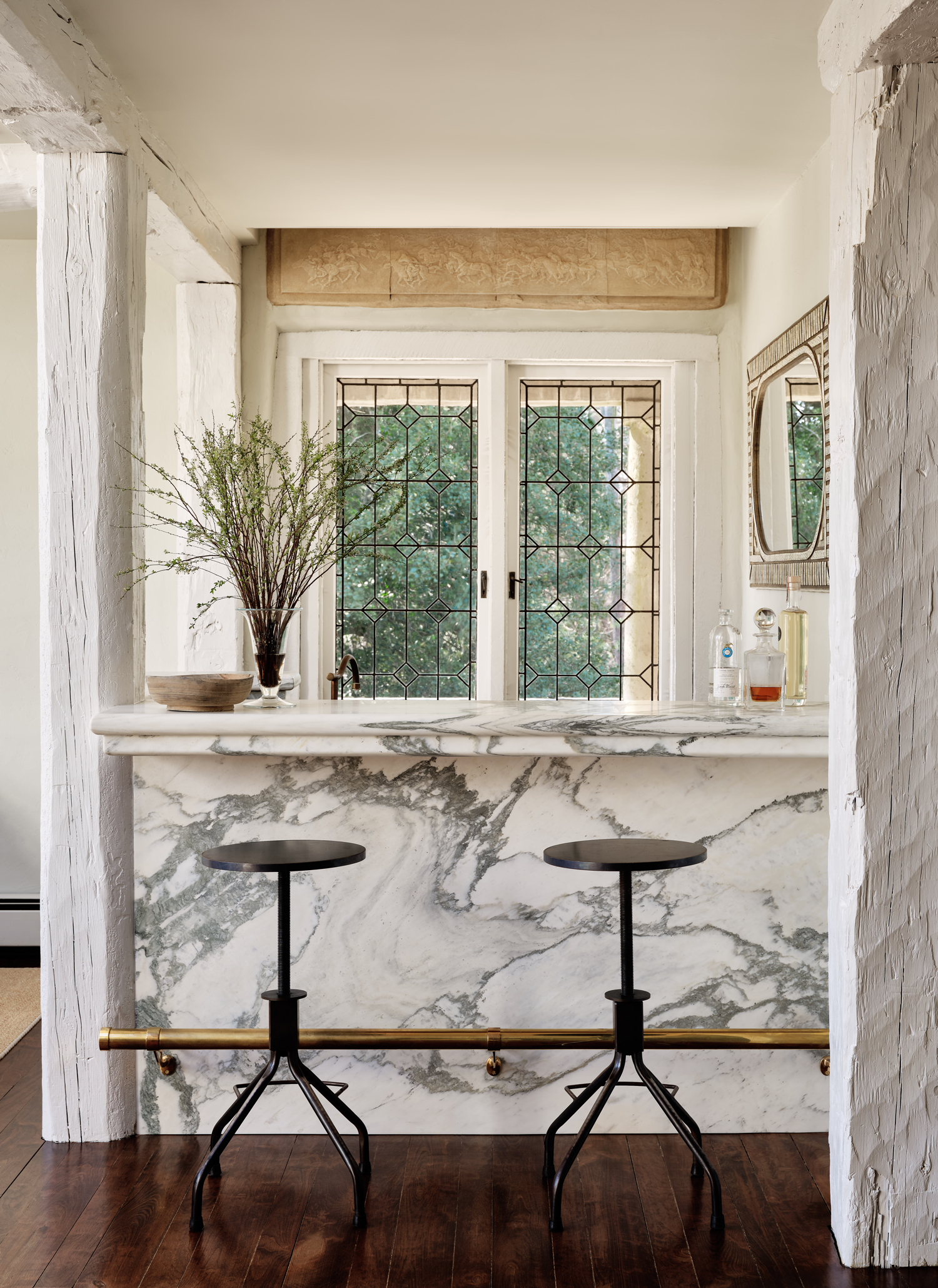 white marble kitchen with brown bar stools, part of 2024 paint color trends