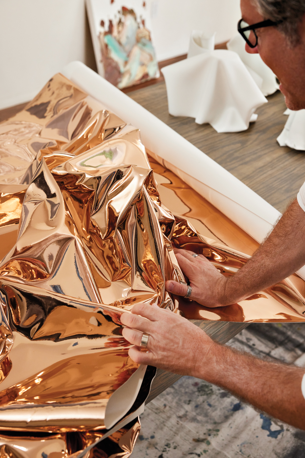 Jason Adkins molding a gold metallic sheet