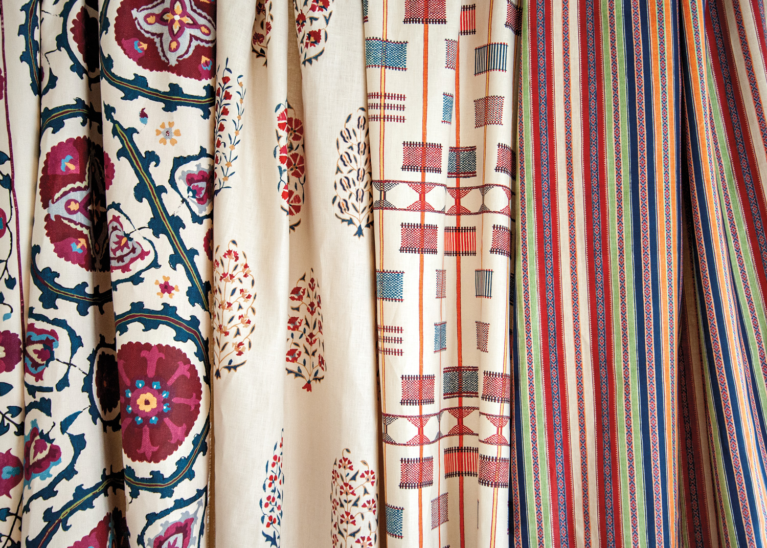Swaths of textile in various patterns hanging side by side.