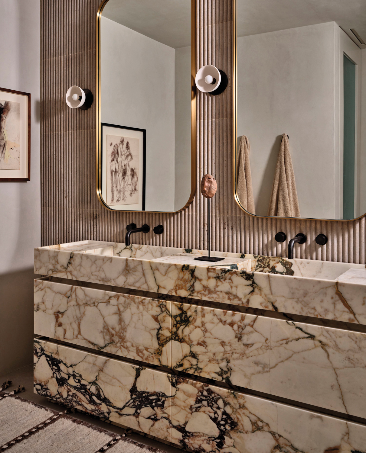 double vanity with fluted marble backsplash and sconces in bathroom by Jenni Lauri