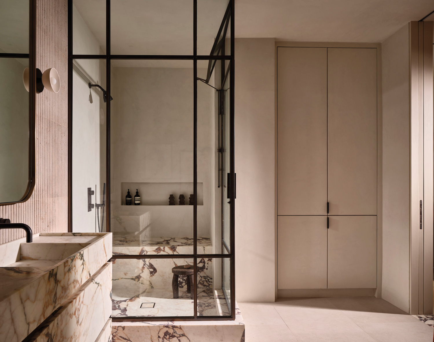 neutral bathroom with glass shower and linen closet by Jenni Lauri of Lauri Design Studio