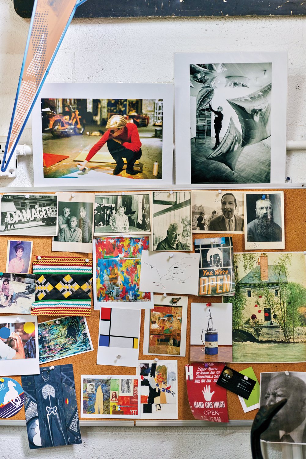 wall of photography and magazine clippings in michael loveland's studio