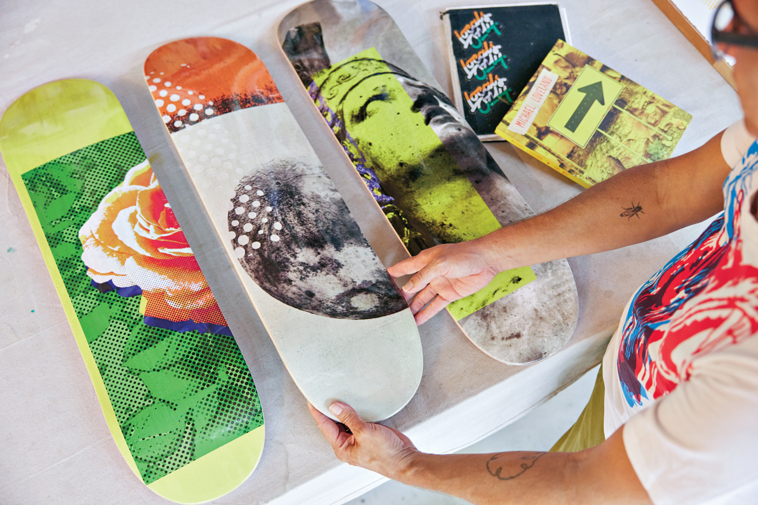 michael loveland holding skateboard forms with collaged elements