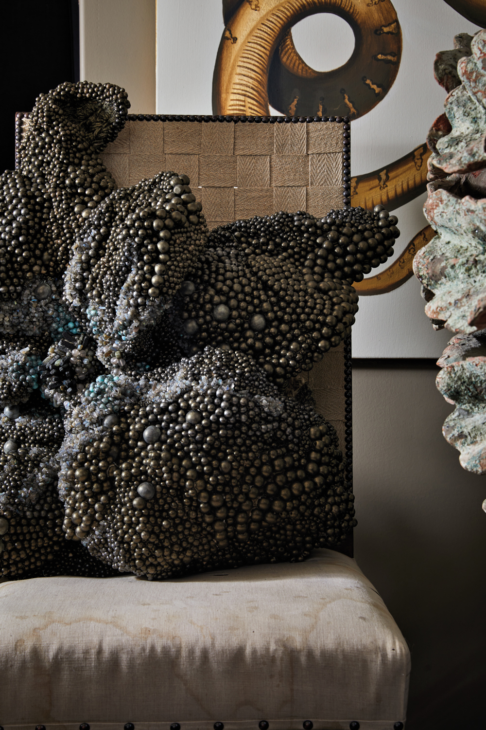 Graphite-colored sculpture with vague references to the starfish form sitting in a chair