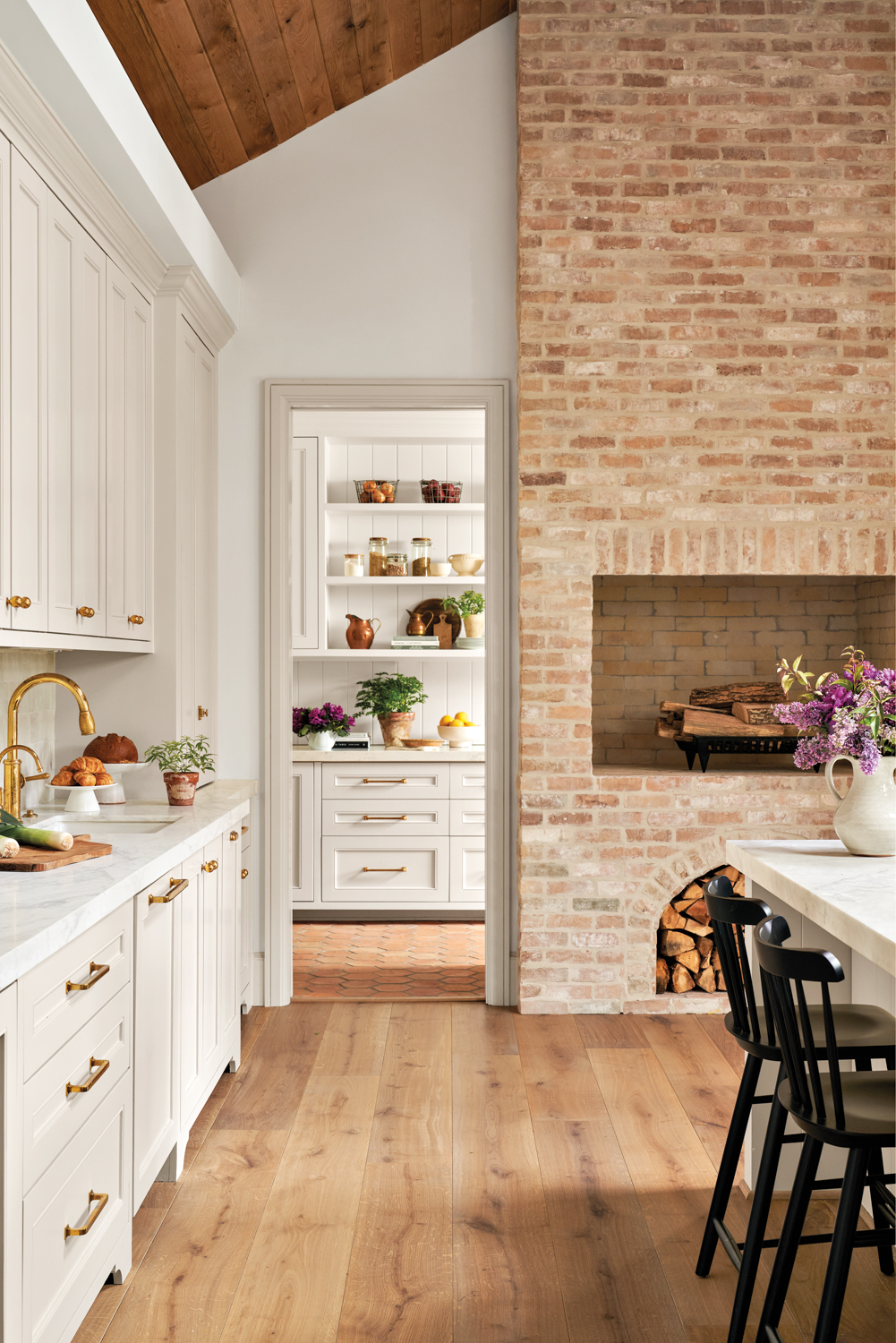 kitchen featuring brick fireplace, white...