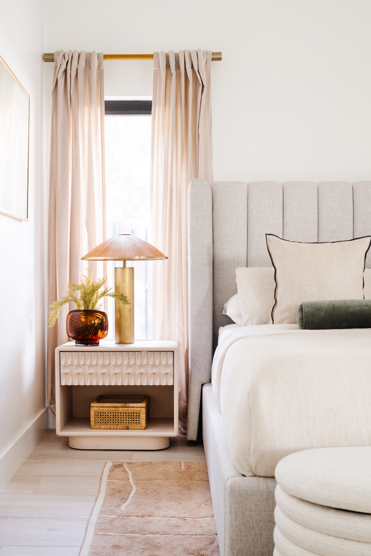 Elegant bedroom, floor to ceiling drapes, single nightstand, grey headboard, white bedding