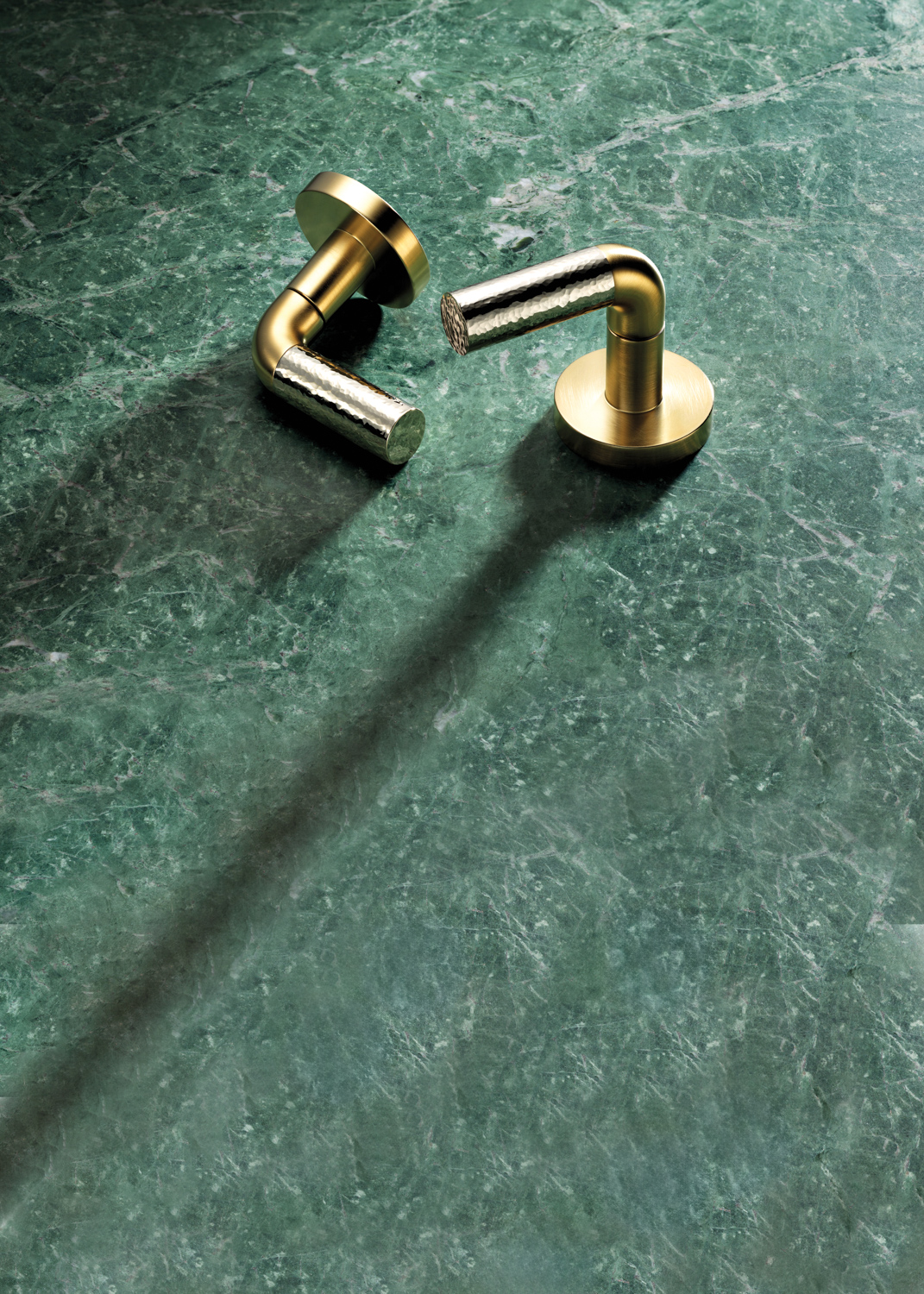 brass fixtures against an emerald green countertop
