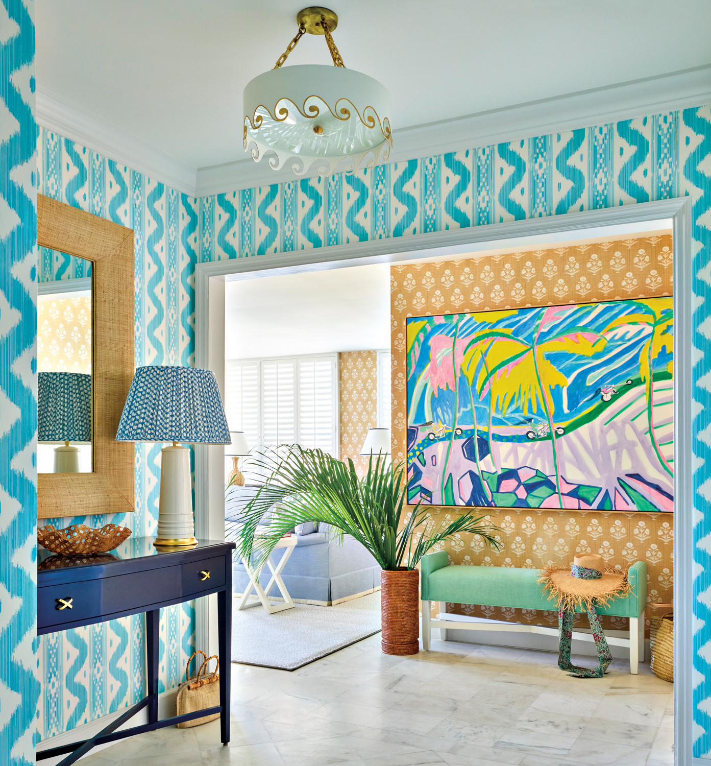 Blue-and-white geometric wallpaper in an entryway leading into a living space with Palm Beach decor by Emily Painter