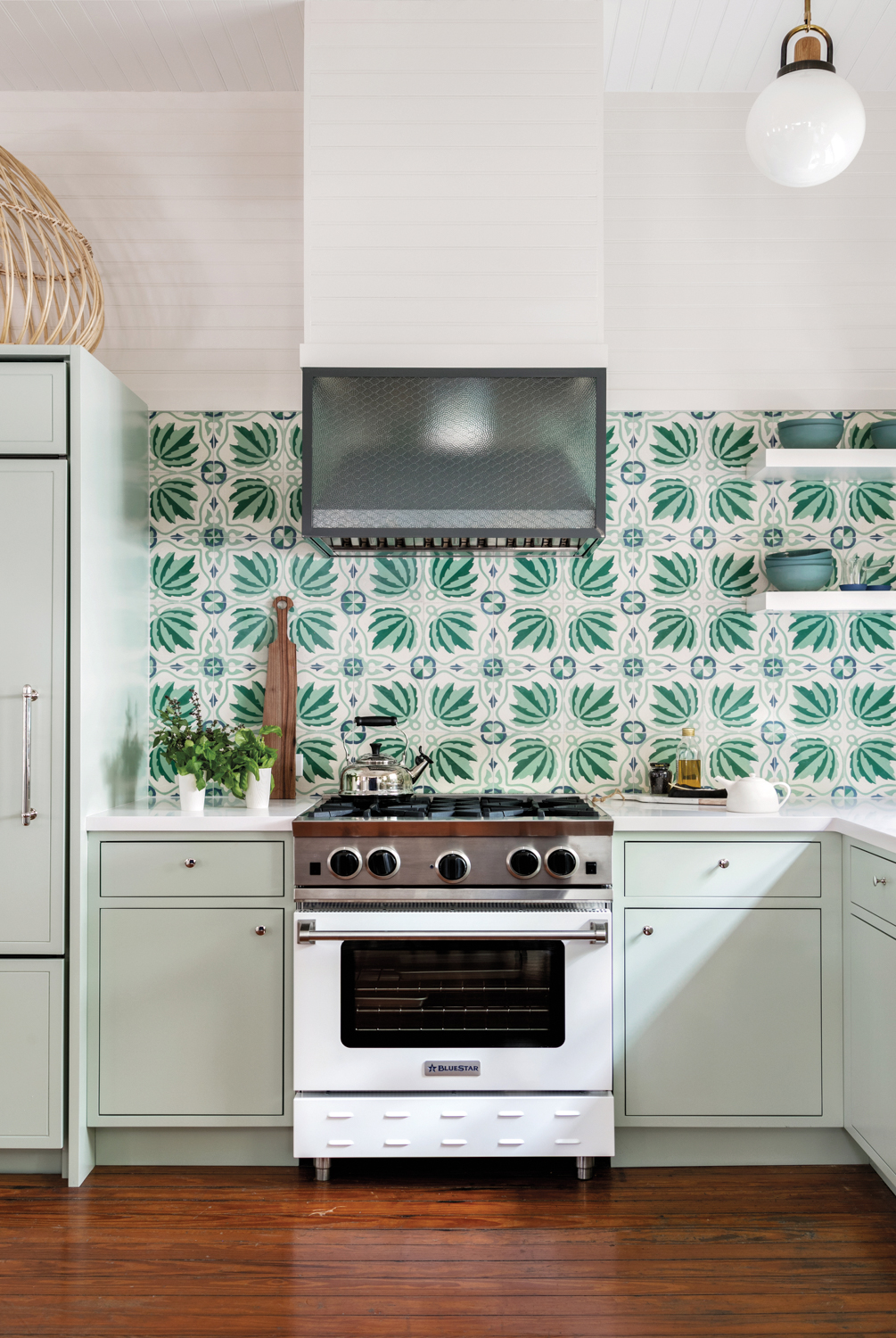 Kitchen with dark wood floors and green-patterned backsplash and mint lower cabinets