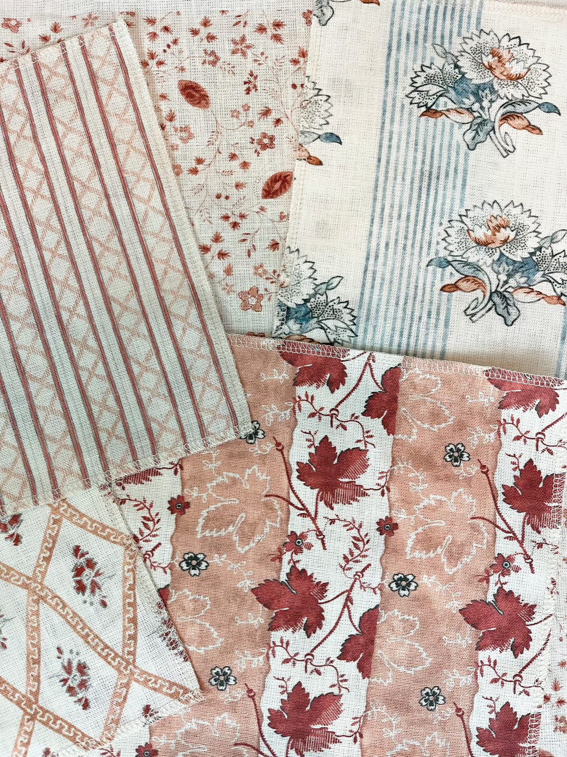 Textile samples of different floral patterns overlaid on top of each other
