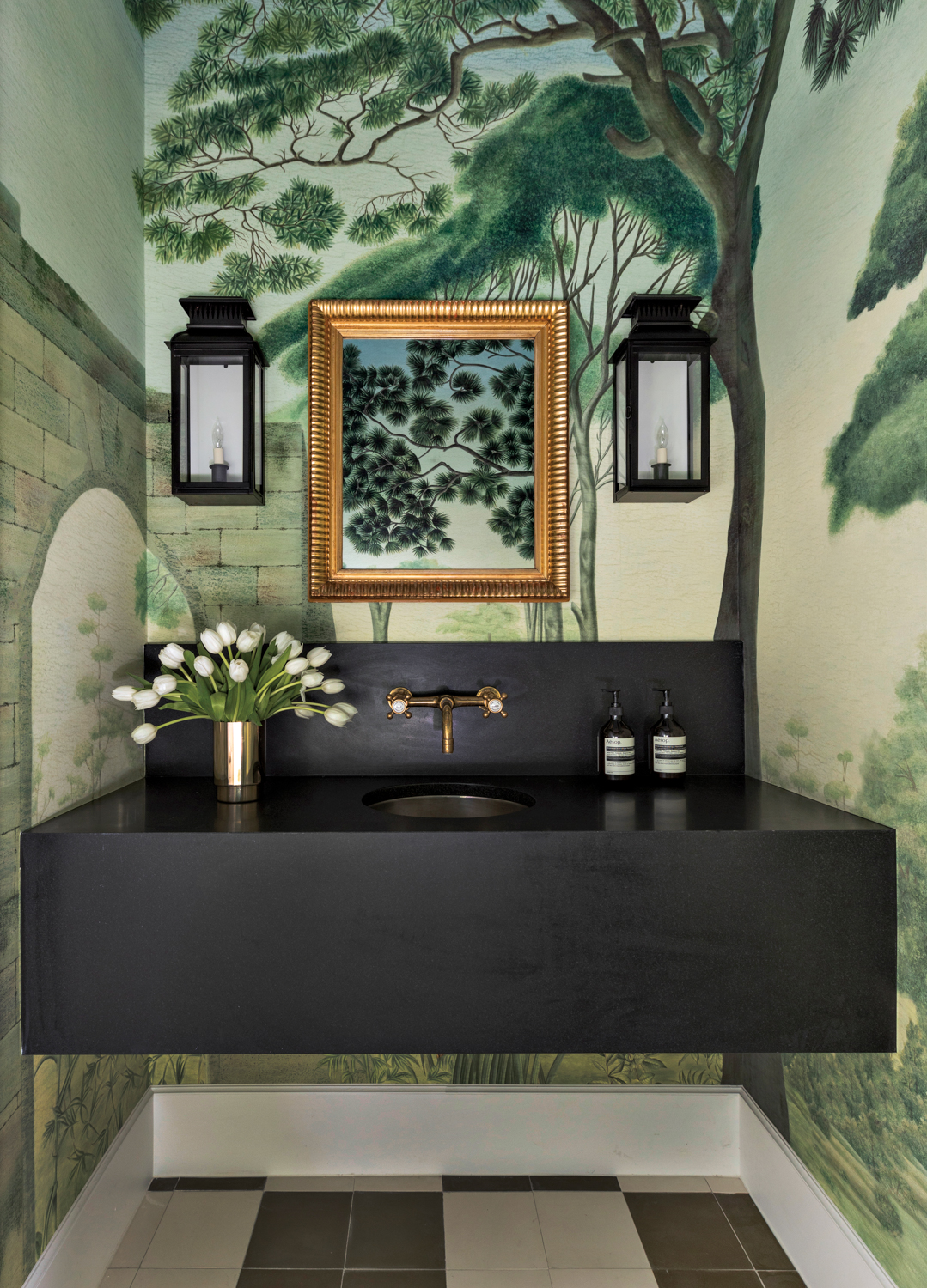 Nature-inspired wallpaper wraps around a powder bath with black vanity and an integrated sink