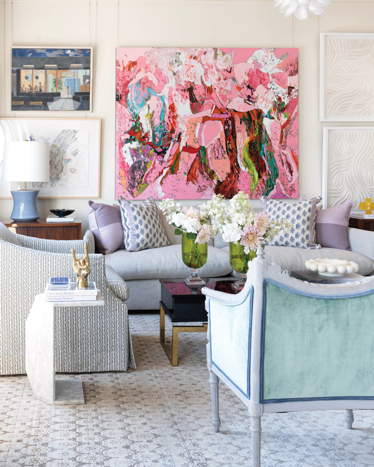 Blue-toned armchairs and a sofa are centered by a large pink abstract painting at Blue Print
