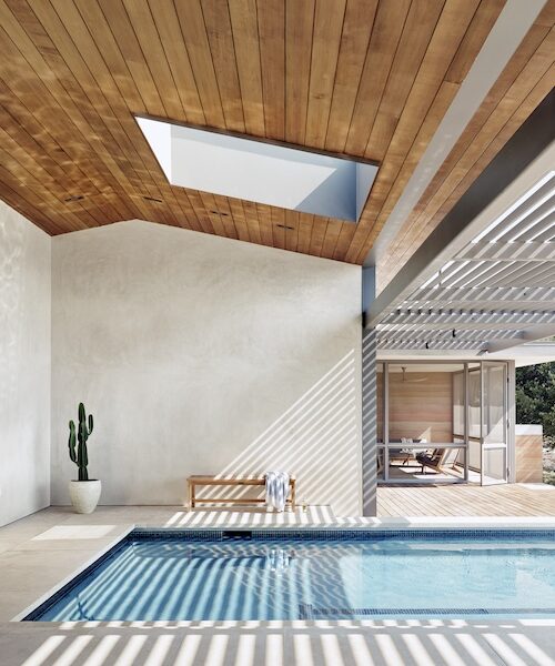 Indoor and outdoor pool with wood beam ceiling.