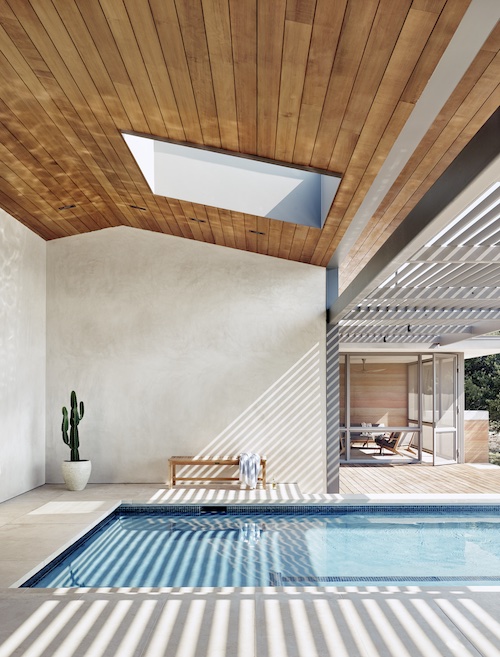 Indoor and outdoor pool with wood beam ceiling.