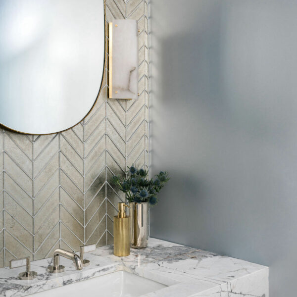 marble countertops in powder room with gold mirror and lighting. Construction Resources provided countertop fabrication and installation