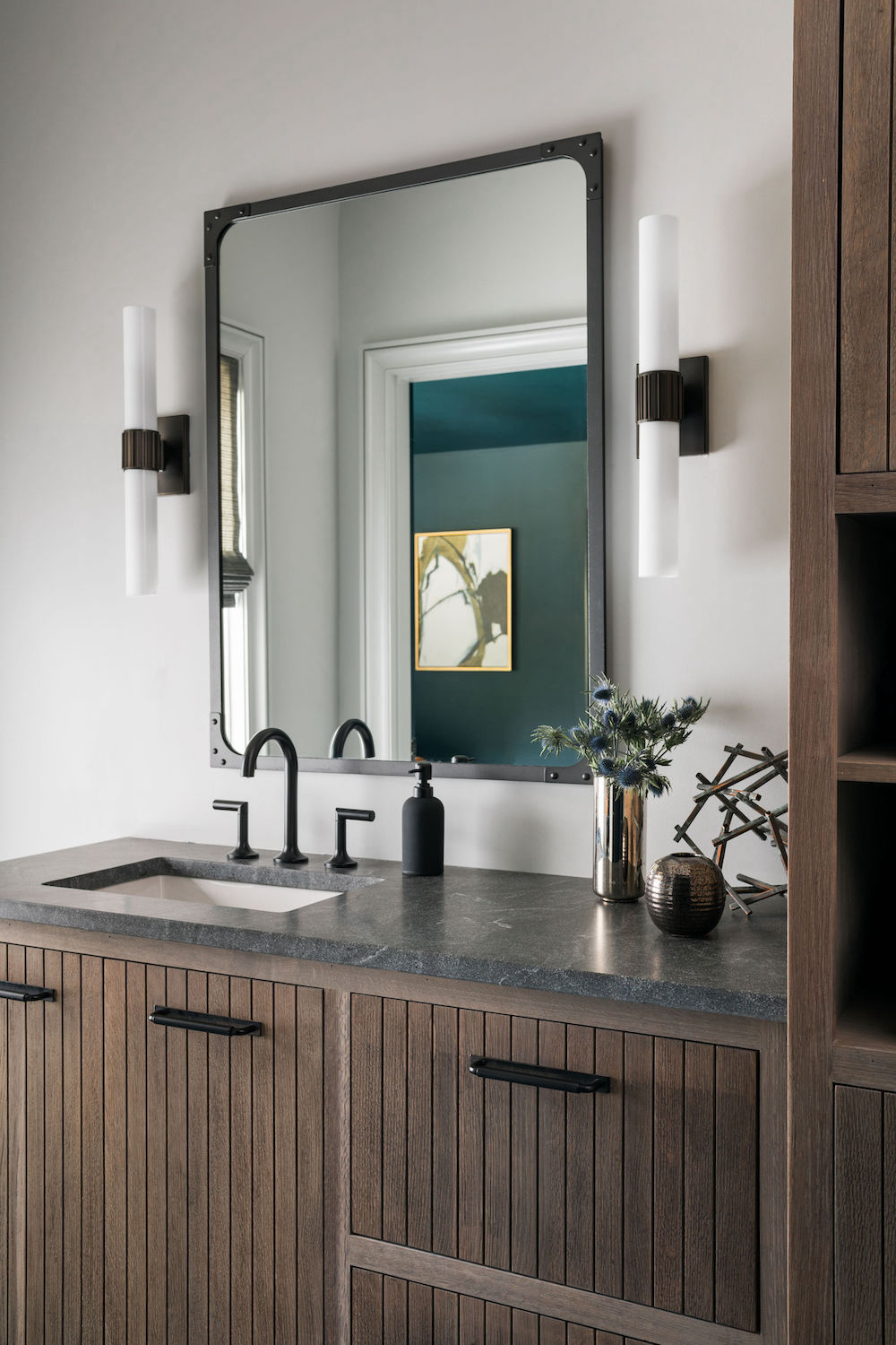 brown wood bathroom cabinets with black faucet and hardware. Construction Resources provided countertop fabrication and installation.