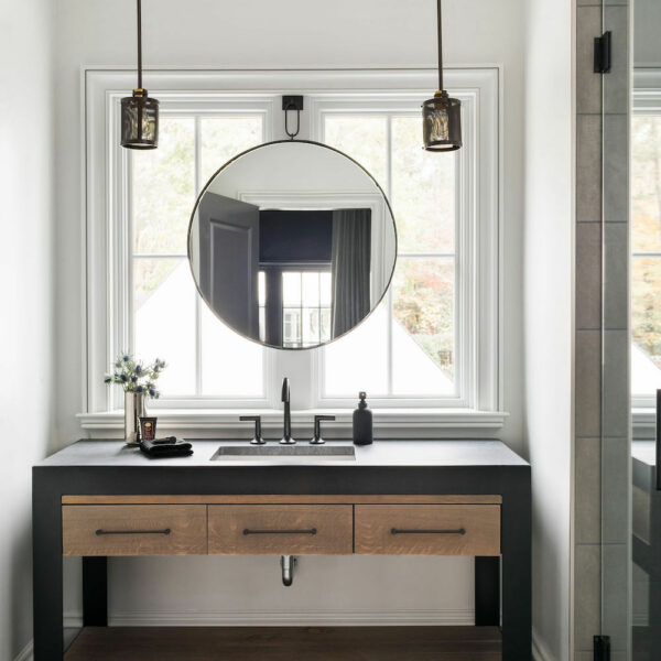 dark and light brown wood bathroom cabinets with black faucet and hardware. Construction Resources provided countertop fabrication and installation.