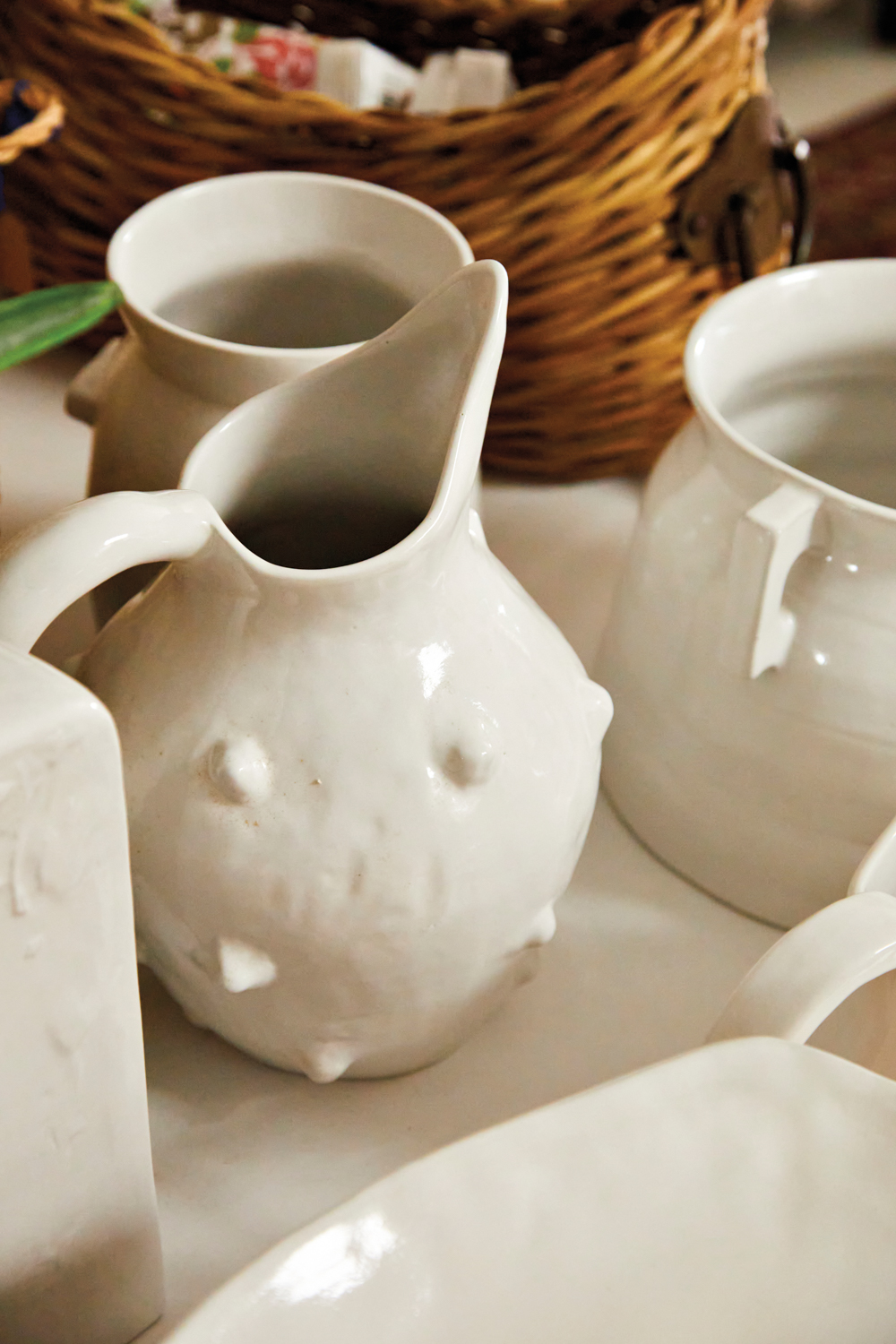 Close-up photo of textured white ceramic vases and pitchers at Mood Indigo