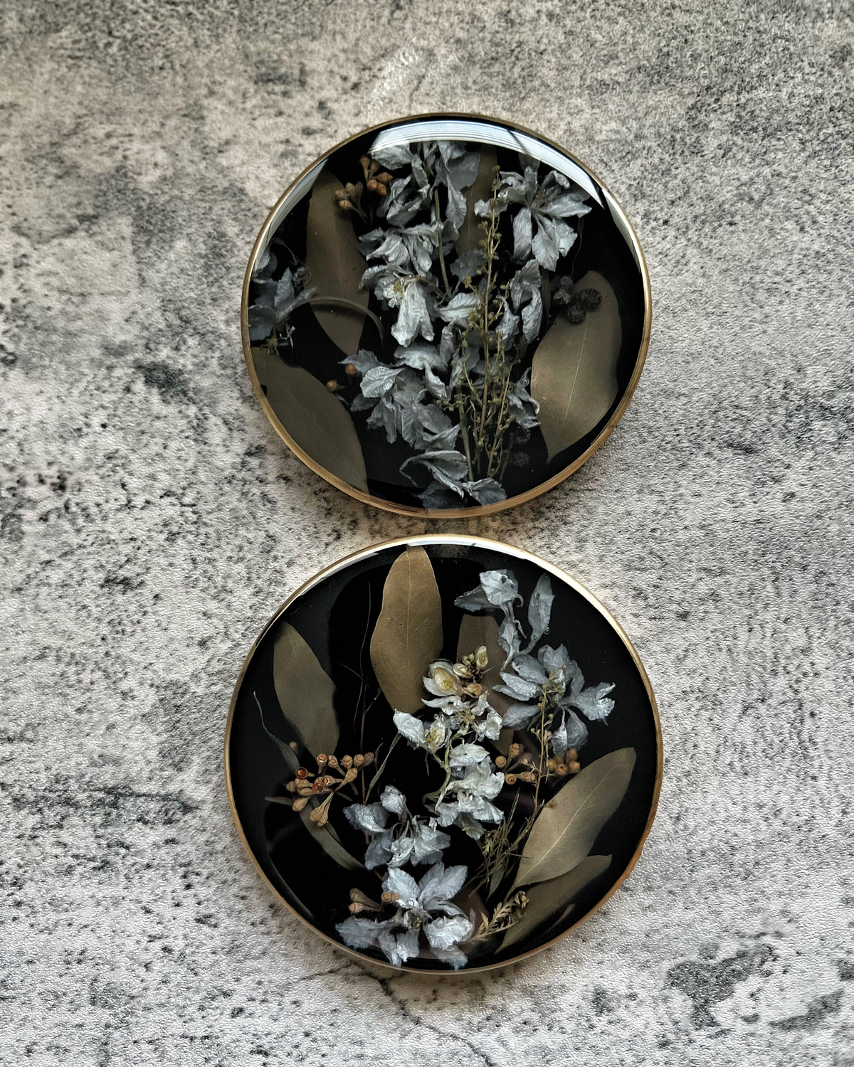 Two circular floral art pieces set in resin by Marie's Floral Art