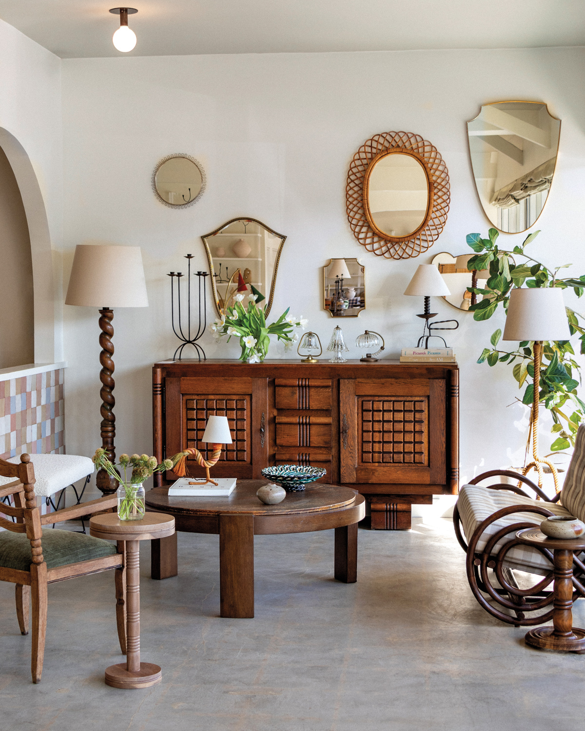 Boutique interior with a carved wooden dresser, a round wooden coffee table and a twisted floor lamp