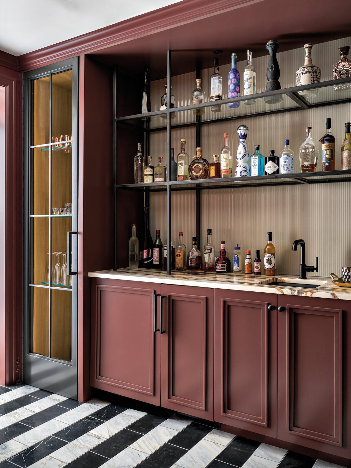 Bar with maroon cabinetry and...