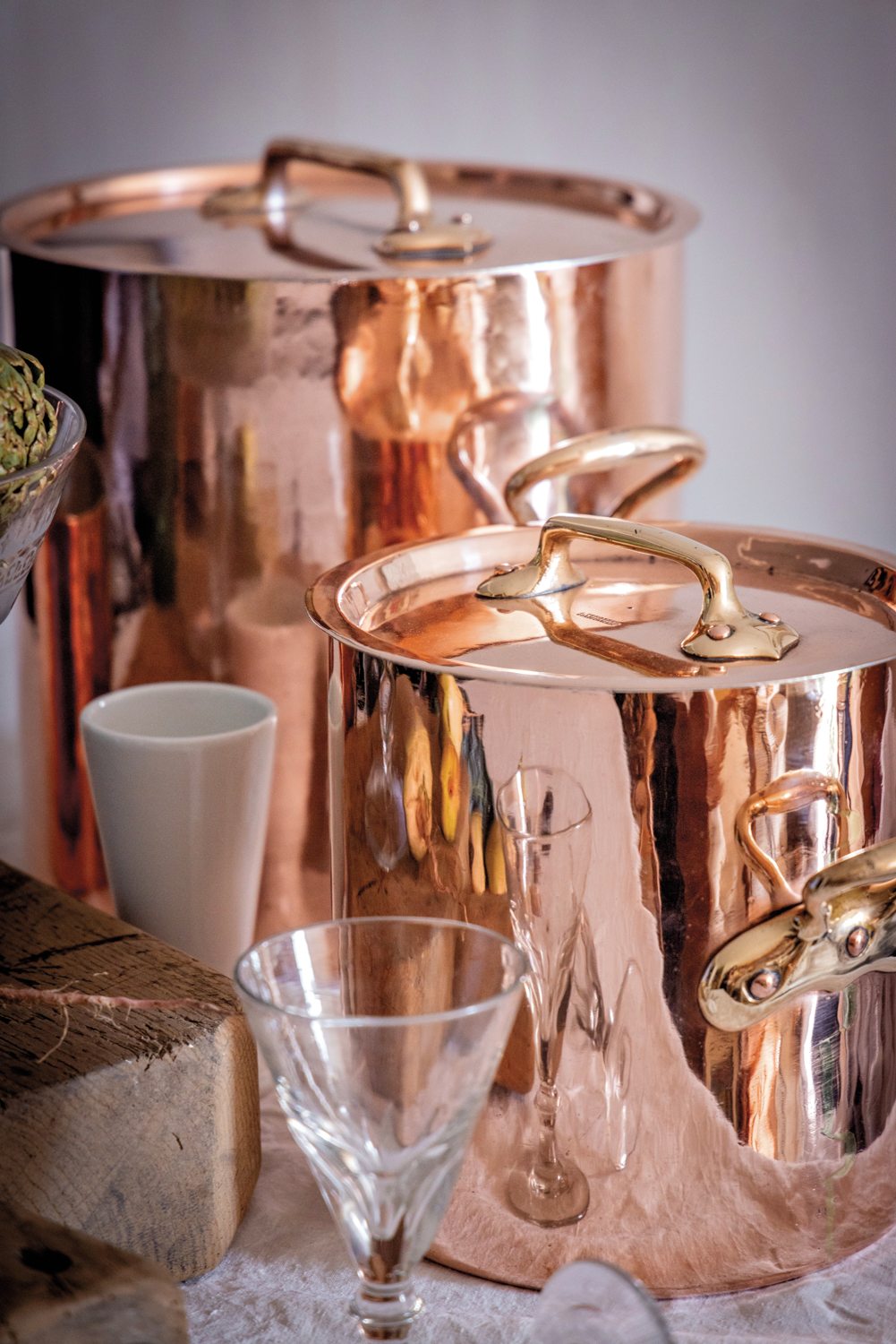 Shiny antique copper pots and glass stemware