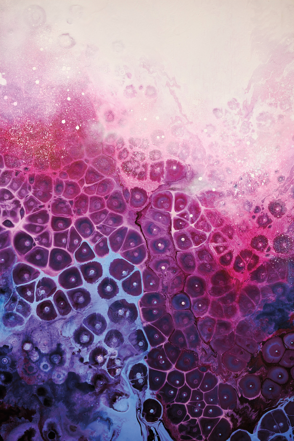 close up of an artist's canvas covered in pink and purple acrylic paint, with cell-like patterns