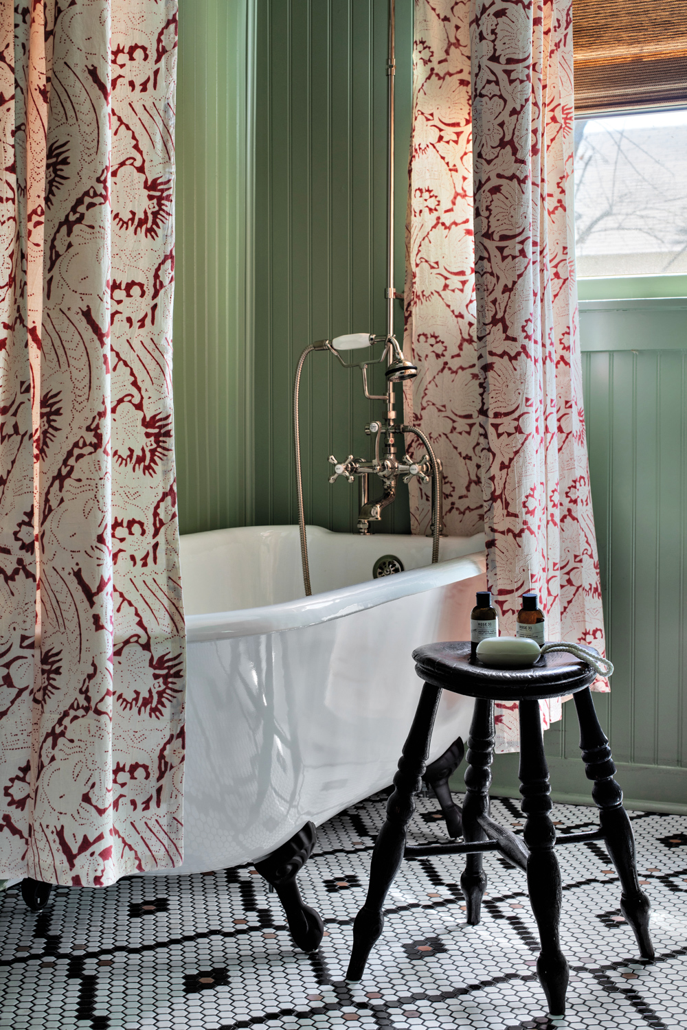 Wet room with patterned curtains and white tub by Sarah Stacey